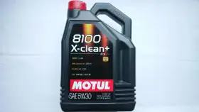 Czarna bańka oleju silnikowego Motul 8100 X-clean+ 5W30 z czerwonym korkiem.